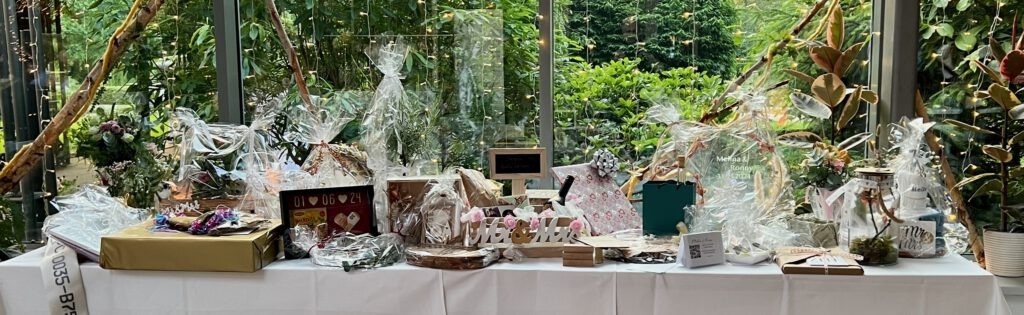 Geschenketisch bei einer Hochzeit in der Blumenhalle Wiesmoor, liebevoll dekoriert mit Blumen, Lichtern und verpackten Präsenten.