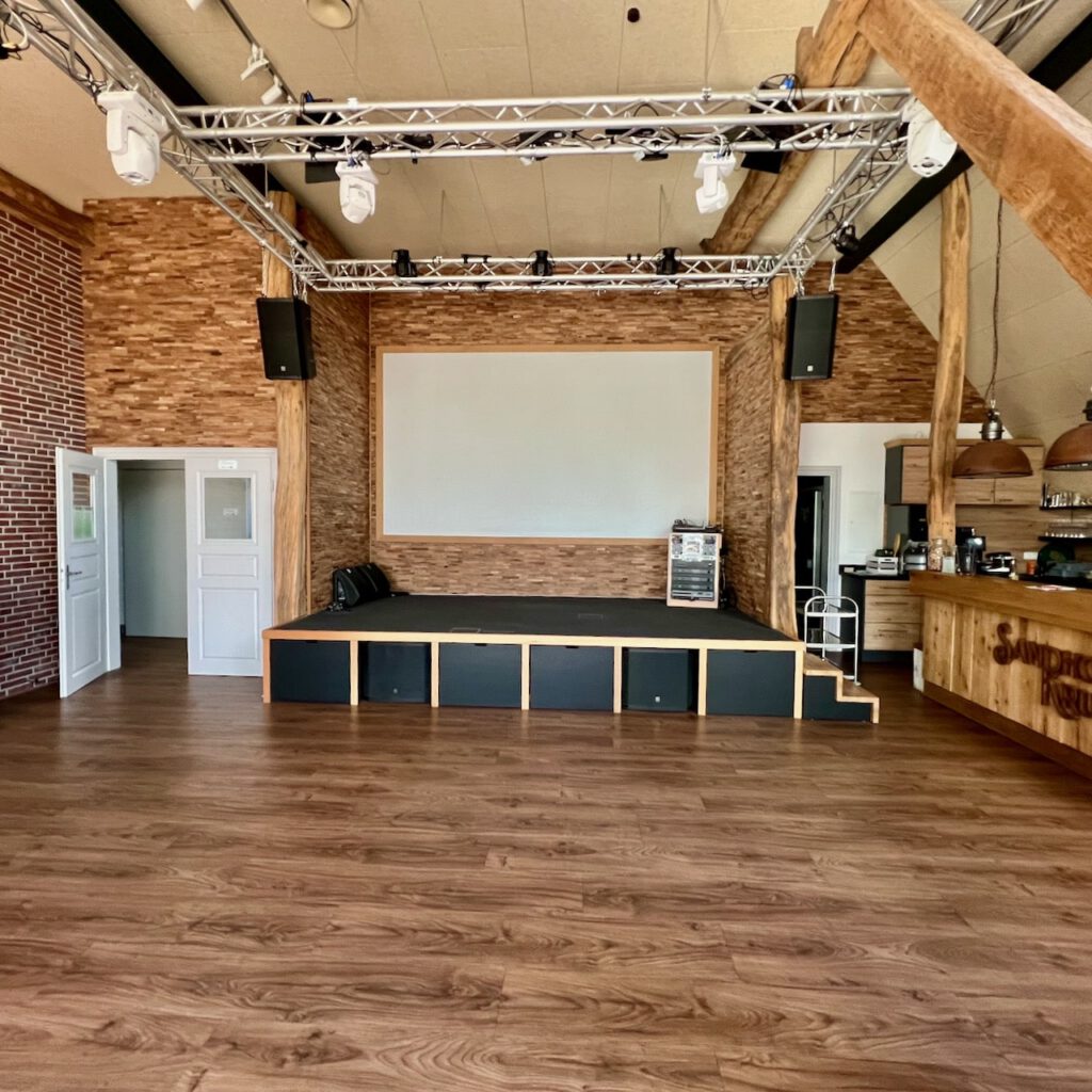 Großer Festsaal mit Bühne und moderner Licht- und Tontechnik im Sandhorster Krug Aurich