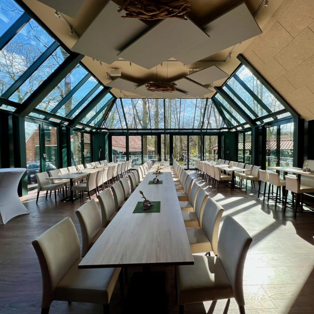 Lichtdurchflutete Orangerie im Sandhorster Krug Aurich, gedeckt für eine Hochzeit