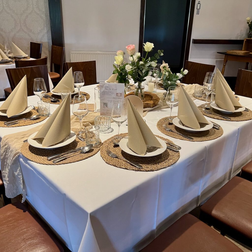 Festlich gedeckter Tisch mit Blumen und Kerzen bei der Hochzeit von Tabea und Heiko im Heidekrug Bentstreek