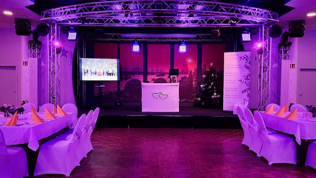 Blick auf die große Bühne und den festlich beleuchteten Saal im Ballhaus Alstertal Hamburg bei einer Hochzeit.