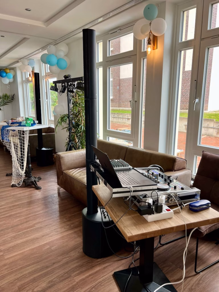 Kompaktes DJ-Setup von DJ Braun4U im Restaurant Krüsch auf Wangerooge – Lichtanlage und Mischpult zwischen Sofas und Ballondekoration