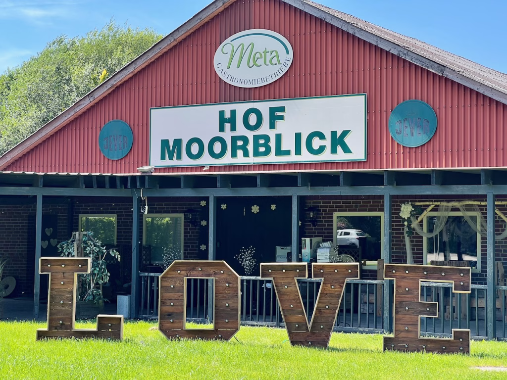 Außenansicht des Hof Moorblick in Großefehn mit LOVE-Buchstaben auf der Wiese bei einer Hochzeitsfeier