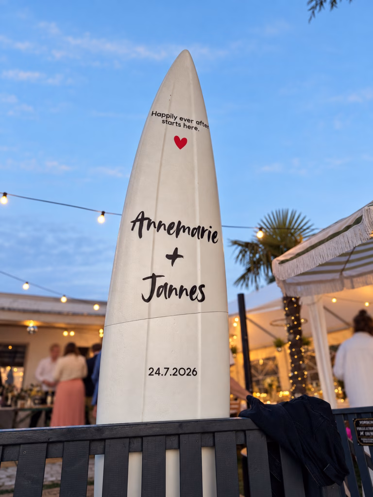 Weißes Surfbrett mit Gästeunterschriften und Zeichnungen als Gästebuch-Alternative bei einer Hochzeit am Meer