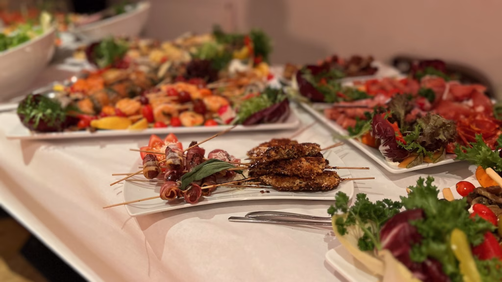 Hochzeitsbuffet mit Spießen, Aufschnitt, Salaten und Gemüse auf weißem Tisch in der Tanzschule Dunse in Wilhelmshaven